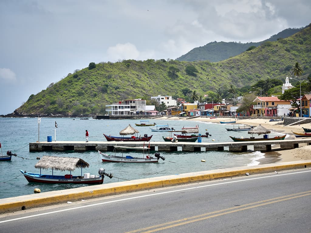 View from the road between Santa Cruz and La Entrega, bay curving, hills green behind.